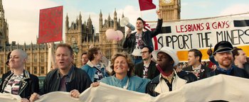Movie still from “Pride” (2014), directed by Matthew Warchus – A group of people standing in front of big ben in london; Medium shot, High angle