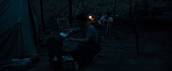 Movie still from “Prince Avalanche” (2013), directed by David Gordon Green – A man and a woman cooking on an outdoor grill; Wide shot, High angle