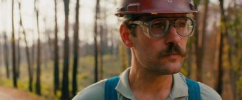 Movie still from “Prince Avalanche” (2013), directed by David Gordon Green – A person wearing glasses and a hard hat; Close Up shot, Low angle