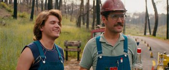 Movie still from “Prince Avalanche” (2013), directed by David Gordon Green – A man and a boy wearing blue overalls and hard hats; Medium shot, Over the shoulder angle