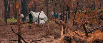 Movie still from “Prince Avalanche” (2013), directed by David Gordon Green – A tent in the middle of the woods with clothes hanging on a clothesline in front of it; Extreme Wide shot, High angle