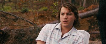 Movie still from “Prince Avalanche” (2013), directed by David Gordon Green – A young man in a plaid shirt is sitting in the woods; Close Up shot, Over the shoulder angle