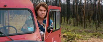 Movie still from “Prince Avalanche” (2013), directed by David Gordon Green – A young man sitting in the driver's seat of a truck; Medium shot, Low angle