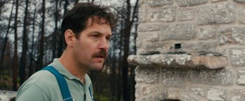 Movie still from “Prince Avalanche” (2013), directed by David Gordon Green – A person with a mustache near a brick wall; Close Up shot, Low angle