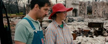 Movie still from “Prince Avalanche” (2013), directed by David Gordon Green – A man standing next to an older woman wearing a red hat; Medium shot, Over the shoulder angle