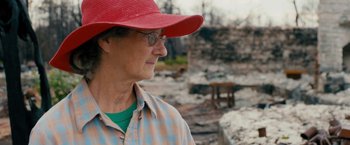 Movie still from “Prince Avalanche” (2013), directed by David Gordon Green – An older woman wearing glasses and a red hat; Close Up shot, Over the shoulder angle
