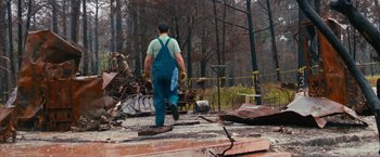 Movie still from “Prince Avalanche” (2013), directed by David Gordon Green – A man in overalls walking through the woods; Wide shot, Over the shoulder angle