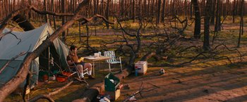 Movie still from “Prince Avalanche” (2013), directed by David Gordon Green – A man sitting at a table in the middle of a forest; Extreme Wide shot, High angle
