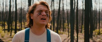 Movie still from “Prince Avalanche” (2013), directed by David Gordon Green – A young man in a white t - shirt is crying in the woods; Close Up shot, Low angle
