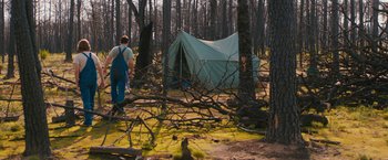 Movie still from “Prince Avalanche” (2013), directed by David Gordon Green – A man standing in the woods next to a tent; Wide shot, High angle