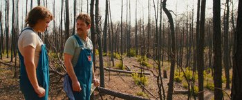 Movie still from “Prince Avalanche” (2013), directed by David Gordon Green – A man in overalls standing in the middle of a forest; Medium shot, Over the shoulder angle