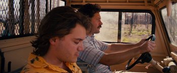 Movie still from “Prince Avalanche” (2013), directed by David Gordon Green – Two men sitting next to each other on a bus; Close Up shot, Low angle