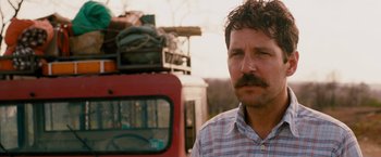 Movie still from “Prince Avalanche” (2013), directed by David Gordon Green – A person standing next to a bus; Close Up shot, Over the shoulder angle