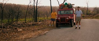 Movie still from “Prince Avalanche” (2013), directed by David Gordon Green – A man standing next to a red truck on the side of the road; Wide shot, Low angle