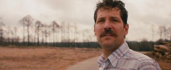 Movie still from “Prince Avalanche” (2013), directed by David Gordon Green – A person with a mustache on a road; Close Up shot, Over the shoulder angle