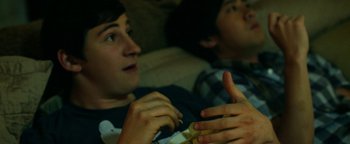 Movie still from “Project Almanac” (2015), directed by Dean Israelite – Two young men sitting on a couch and talking to each other; Close Up shot, Over the shoulder angle