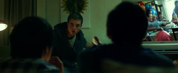 Movie still from “Project Almanac” (2015), directed by Dean Israelite – A young man sitting in front of another young man; Medium shot, Over the shoulder angle