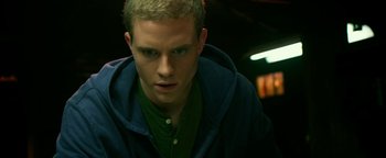 Movie still from “Project Almanac” (2015), directed by Dean Israelite – A man with a green shirt and a blue hooded jacket; Close Up shot, Low angle