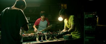 Movie still from “Project Almanac” (2015), directed by Dean Israelite – Two men working in an electronics shop; Medium shot, Low angle