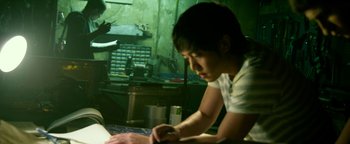 Movie still from “Project Almanac” (2015), directed by Dean Israelite – A young man using a computer at a desk; Medium shot, Over the shoulder angle