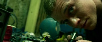 Movie still from “Project Almanac” (2015), directed by Dean Israelite – A person's face in a pile of electronics; Extreme Close Up shot, Low angle
