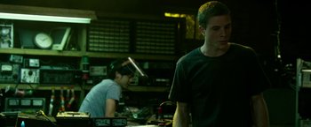 Movie still from “Project Almanac” (2015), directed by Dean Israelite – Two young men are working together in a shop; Medium shot, Low angle