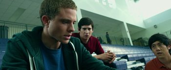 Movie still from “Project Almanac” (2015), directed by Dean Israelite – Two young men are sitting in a bleachers; Medium shot, Low angle