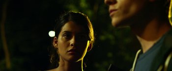 Movie still from “Project Almanac” (2015), directed by Dean Israelite – A woman standing next to a man in the dark; Close Up shot, Over the shoulder angle