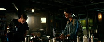 Movie still from “Project Almanac” (2015), directed by Dean Israelite – A woman standing at a table with a pan in front of her; Medium shot, Low angle