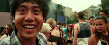 Movie still from “Project Almanac” (2015), directed by Dean Israelite – A group of people standing in a crowd at an outdoor event; Close Up shot, Over the shoulder angle
