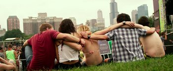 Movie still from “Project Almanac” (2015), directed by Dean Israelite – A group of people sitting in the grass with their arms around one another; Wide shot, High angle