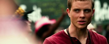 Movie still from “Project Almanac” (2015), directed by Dean Israelite – A young man in a red shirt is looking at the camera; Close Up shot, Over the shoulder angle