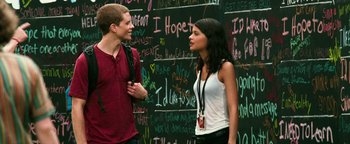 Movie still from “Project Almanac” (2015), directed by Dean Israelite – A man and a woman standing next to each other in front of a chalkboard; Medium shot, Over the shoulder angle