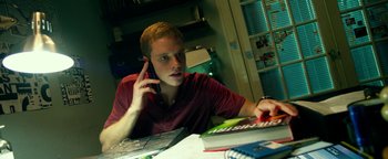 Movie still from “Project Almanac” (2015), directed by Dean Israelite – A man sitting at a table talking on a phone; Close Up shot, Low angle