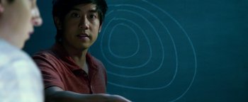 Movie still from “Project Almanac” (2015), directed by Dean Israelite – A man in a red shirt sitting in front of a blue background; Close Up shot, Overhead angle