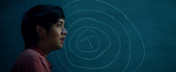 Movie still from “Project Almanac” (2015), directed by Dean Israelite – A woman standing in front of a chalkboard; Close Up shot, Overhead angle