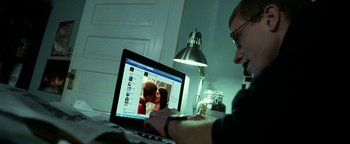 Movie still from “Project Almanac” (2015), directed by Dean Israelite – A man sitting in front of a computer screen; Medium shot, Over the shoulder angle