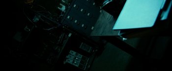 Movie still from “Project Almanac” (2015), directed by Dean Israelite – An overhead view of a dark room with a lot of cabinets; Wide shot, High angle