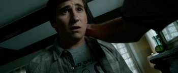 Movie still from “Project Almanac” (2015), directed by Dean Israelite – A young man is looking at the camera while another man is touching his shoulder; Close Up shot, Over the shoulder angle