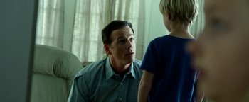 Movie still from “Project Almanac” (2015), directed by Dean Israelite – A man talking to a boy in a blue shirt; Close Up shot, Over the shoulder angle