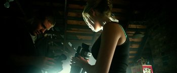 Movie still from “Project Almanac” (2015), directed by Dean Israelite – A woman is holding a camera in a room; Medium shot, Low angle