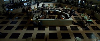 Movie still from “Public Enemies” (2009), directed by Michael Mann – People are sitting at tables in an office building; Extreme Wide shot, High angle