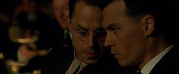 Movie still from “Public Enemies” (2009), directed by Michael Mann – Two men in suits are looking at each other; Close Up shot, High angle