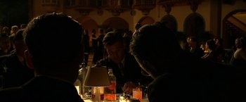Movie still from “Public Enemies” (2009), directed by Michael Mann – A group of people sitting at a table with drinks; Medium shot, High angle