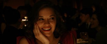 Movie still from “Public Enemies” (2009), directed by Michael Mann – A woman smiling with her hand on her face; Close Up shot, High angle