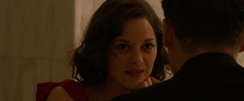 Movie still from “Public Enemies” (2009), directed by Michael Mann – A young woman with short brown curly hair looking at the camera; Close Up shot, Over the shoulder angle
