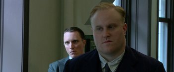 Movie still from “Public Enemies” (2009), directed by Michael Mann – Two men in suits and ties are looking at the camera; Close Up shot, Low angle