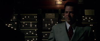 Movie still from “Public Enemies” (2009), directed by Michael Mann – A man standing in front of a wall of organ pipes; Medium shot, Low angle