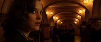 Movie still from “Public Enemies” (2009), directed by Michael Mann – A woman standing next to a group of people; Close Up shot, Over the shoulder angle