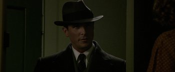 Movie still from “Public Enemies” (2009), directed by Michael Mann – A man wearing a hat and a suit and tie; Close Up shot, Low angle